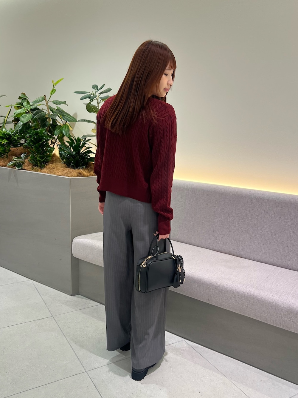 レッド系のアンサンブル、ブラック系のローファー、グレー系のその他パンツを着用したレディースの秋コーディネートの7枚目の写真