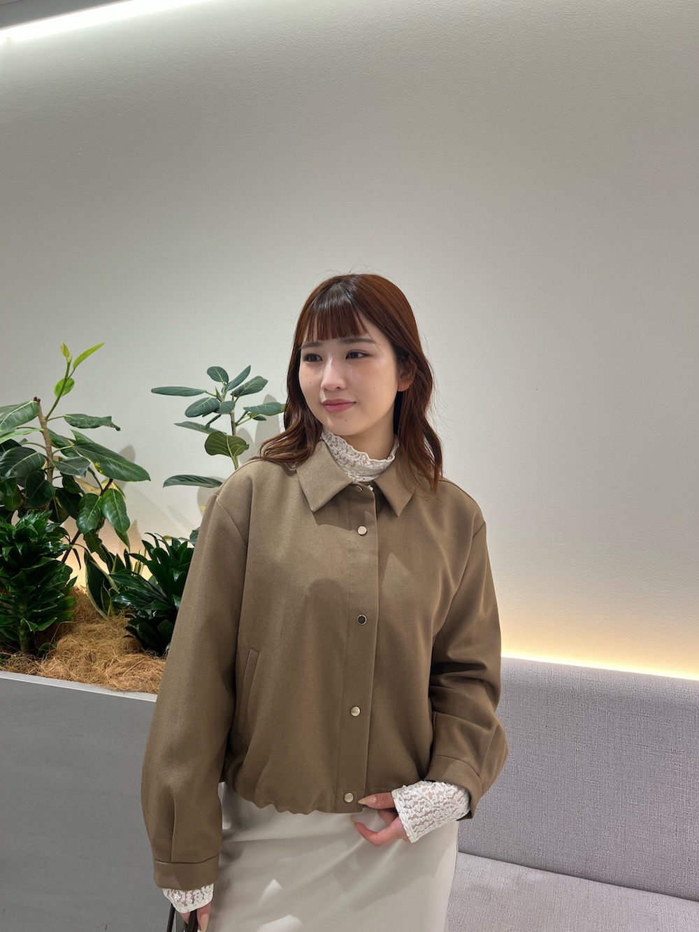 ブラウン系のブルゾン、ホワイト系のTシャツ/カットソー、ブラウン系のボストンバッグを着用したレディースの秋コーディネートの8枚目の写真