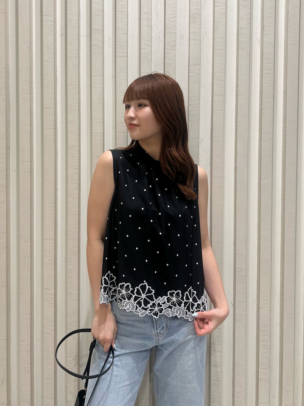 ブラック系のシャツ/ブラウス、ブラック系のショルダーバッグ、ブルー系のデニムパンツを着用したレディースの夏コーディネートの5枚目の写真
