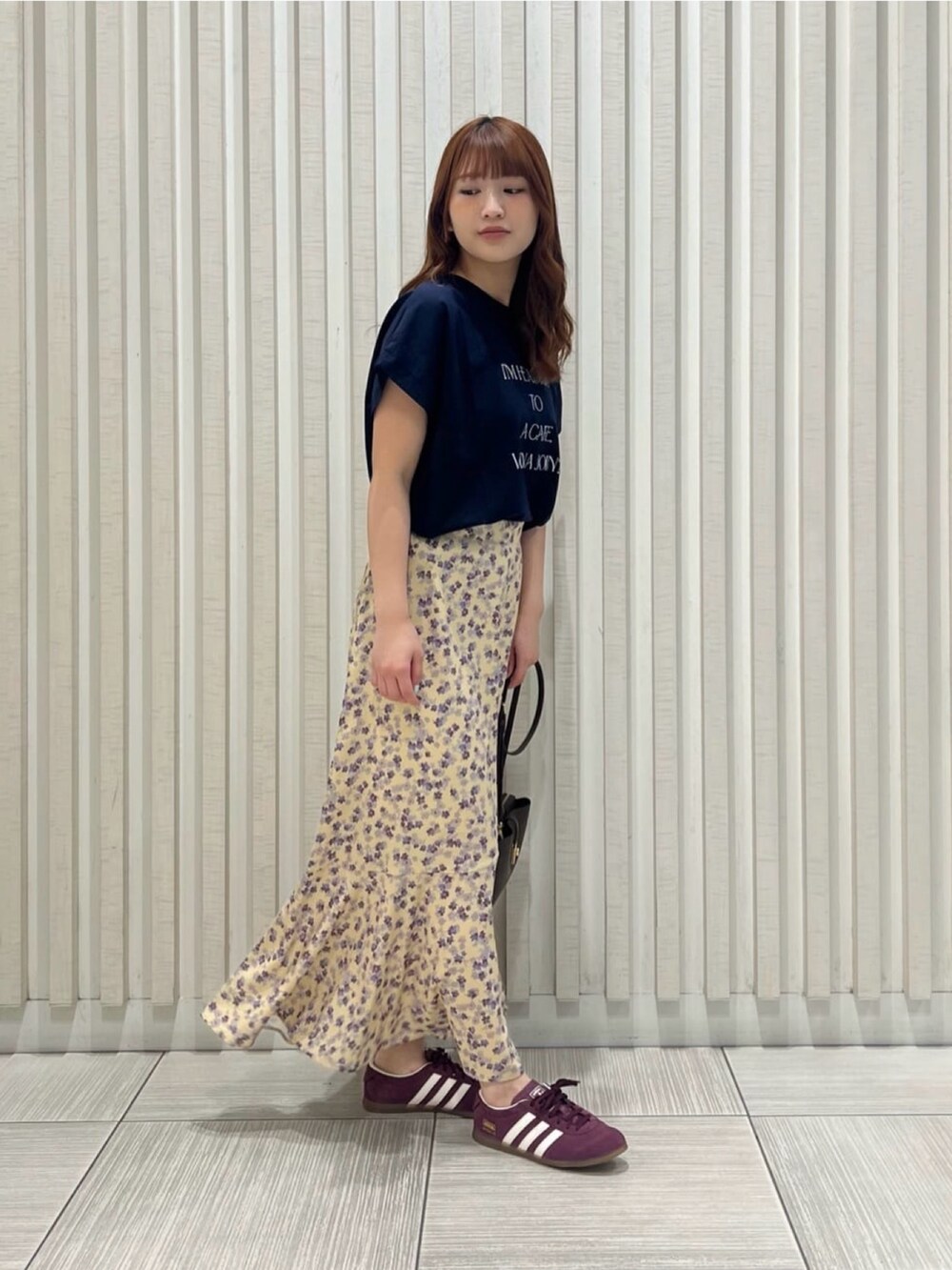 ブルー系のTシャツ/カットソー、イエロー系のスカート、ブラック系のショルダーバッグを着用したレディースの夏コーディネートの4枚目の写真