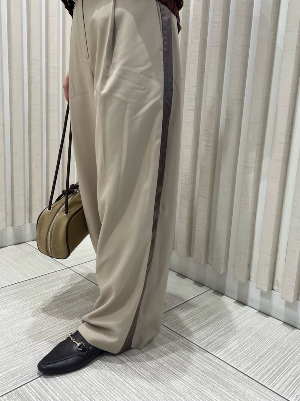 ベージュ系のその他パンツ、ブラウン系のベスト、ベージュ系のボストンバッグを着用したレディースの夏コーディネートの7枚目の写真