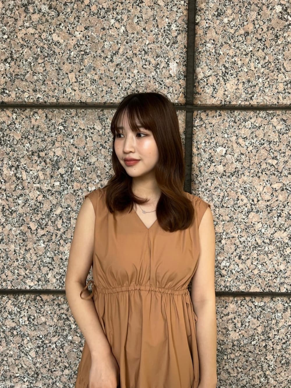 イエロー系のワンピース、ブラウン系のサンダル、ブラウン系のボストンバッグを着用したレディースの夏コーディネートの5枚目の写真