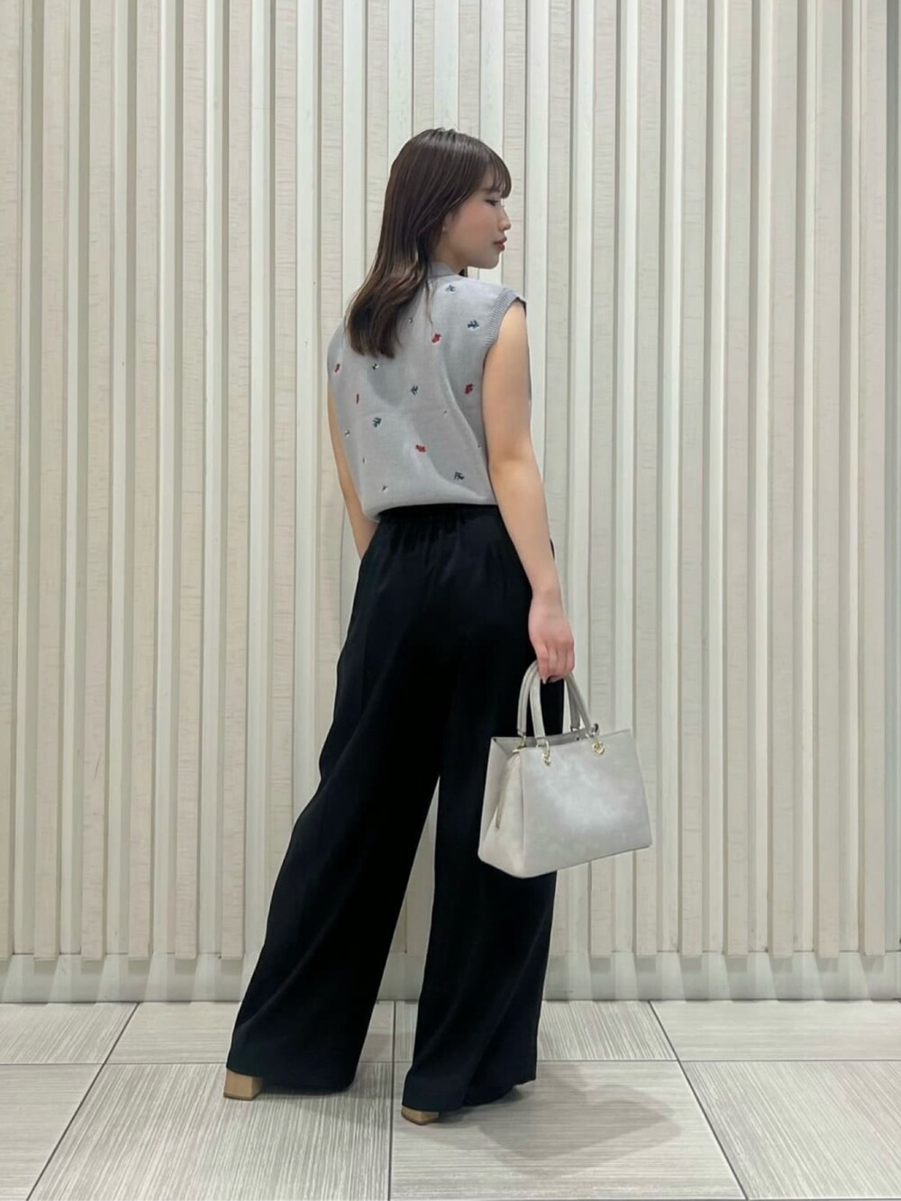 グレー系のポロシャツ、ブラック系のその他パンツ、グレー系のトートバッグを着用したレディースの夏コーディネートの4枚目の写真