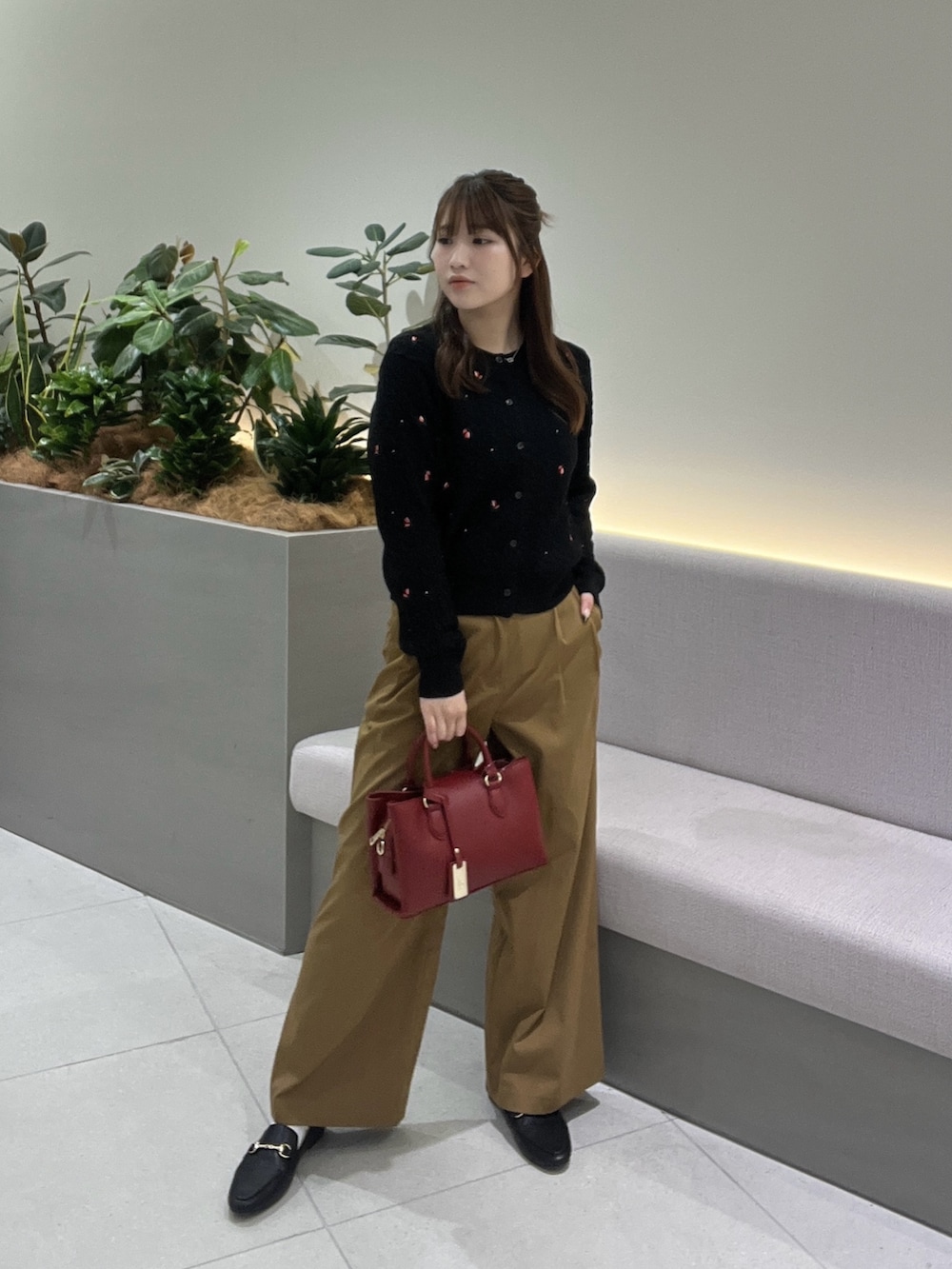 ブラック系のカーディガン/ボレロ、イエロー系のその他パンツ、レッド系のショルダーバッグを着用したレディースの秋コーディネートの3枚目の写真
