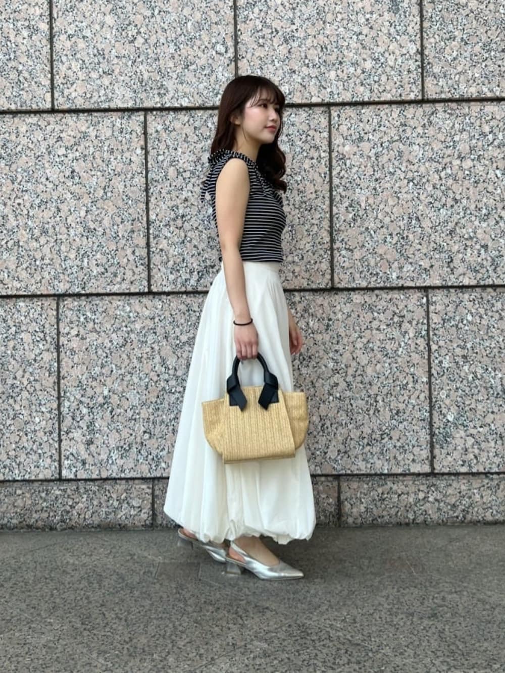 ホワイト系のスカート、ブルー系のTシャツ/カットソー、ベージュ系のトートバッグを着用したレディースの夏コーディネートの2枚目の写真