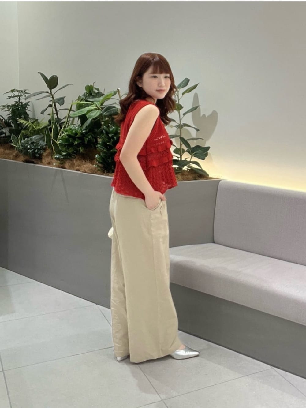レッド系のニット/セーター、ベージュ系のその他パンツ、ブラウン系のボストンバッグを着用したレディースの夏コーディネートの3枚目の写真