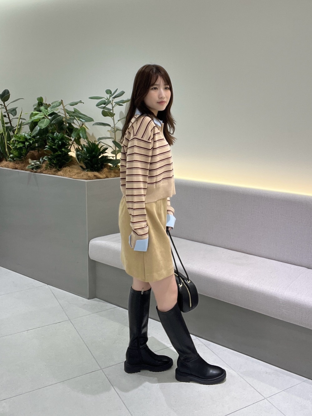 ベージュ系のニット/セーター、ベージュ系のスカート、ブラック系のブーツを着用したレディースの夏コーディネートの4枚目の写真