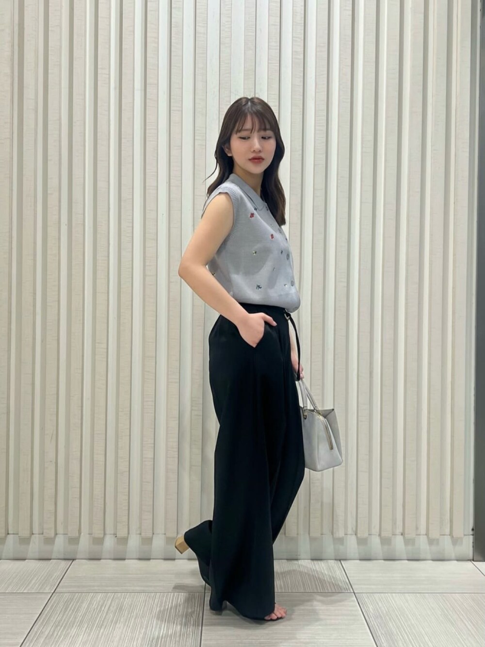 グレー系のポロシャツ、ブラック系のその他パンツ、グレー系のトートバッグを着用したレディースの夏コーディネートの3枚目の写真