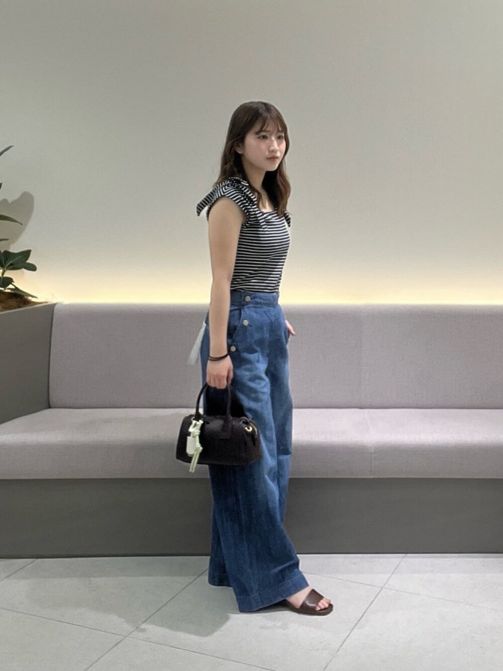 ブルー系のTシャツ/カットソー、ブルー系のデニムパンツ、ブラウン系のサンダルを着用したレディースの夏コーディネートの3枚目の写真