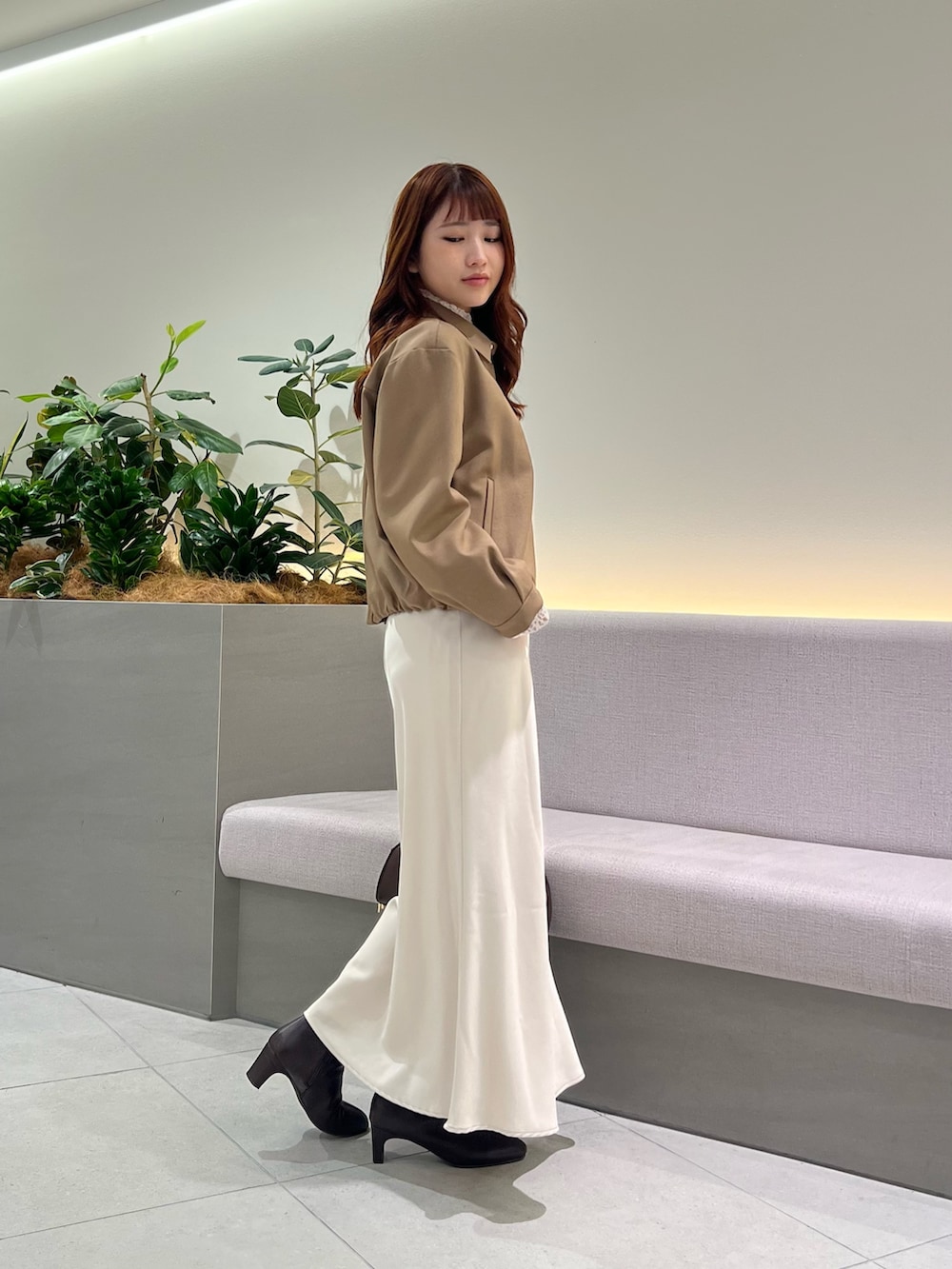 ブラウン系のブルゾン、ホワイト系のTシャツ/カットソー、ブラウン系のボストンバッグを着用したレディースの秋コーディネートの5枚目の写真
