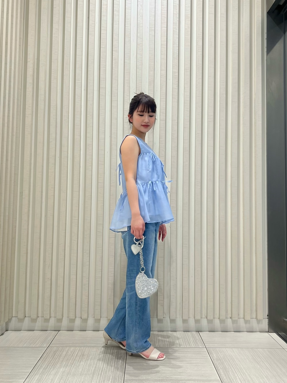 ブルー系のシャツ/ブラウス、ブルー系のデニムパンツ、ホワイト系のサンダルを着用したレディースの夏コーディネートの3枚目の写真