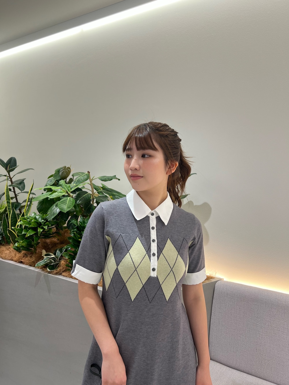 グレー系のワンピース、ブラック系のブーツ、ブラック系のショルダーバッグを着用したレディースの秋コーディネートの8枚目の写真