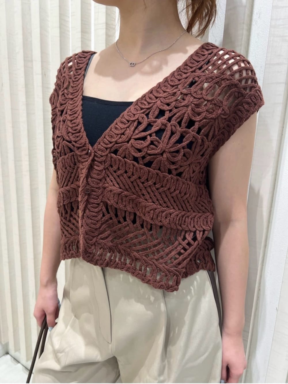 ベージュ系のその他パンツ、ブラウン系のベスト、ベージュ系のボストンバッグを着用したレディースの夏コーディネートの6枚目の写真