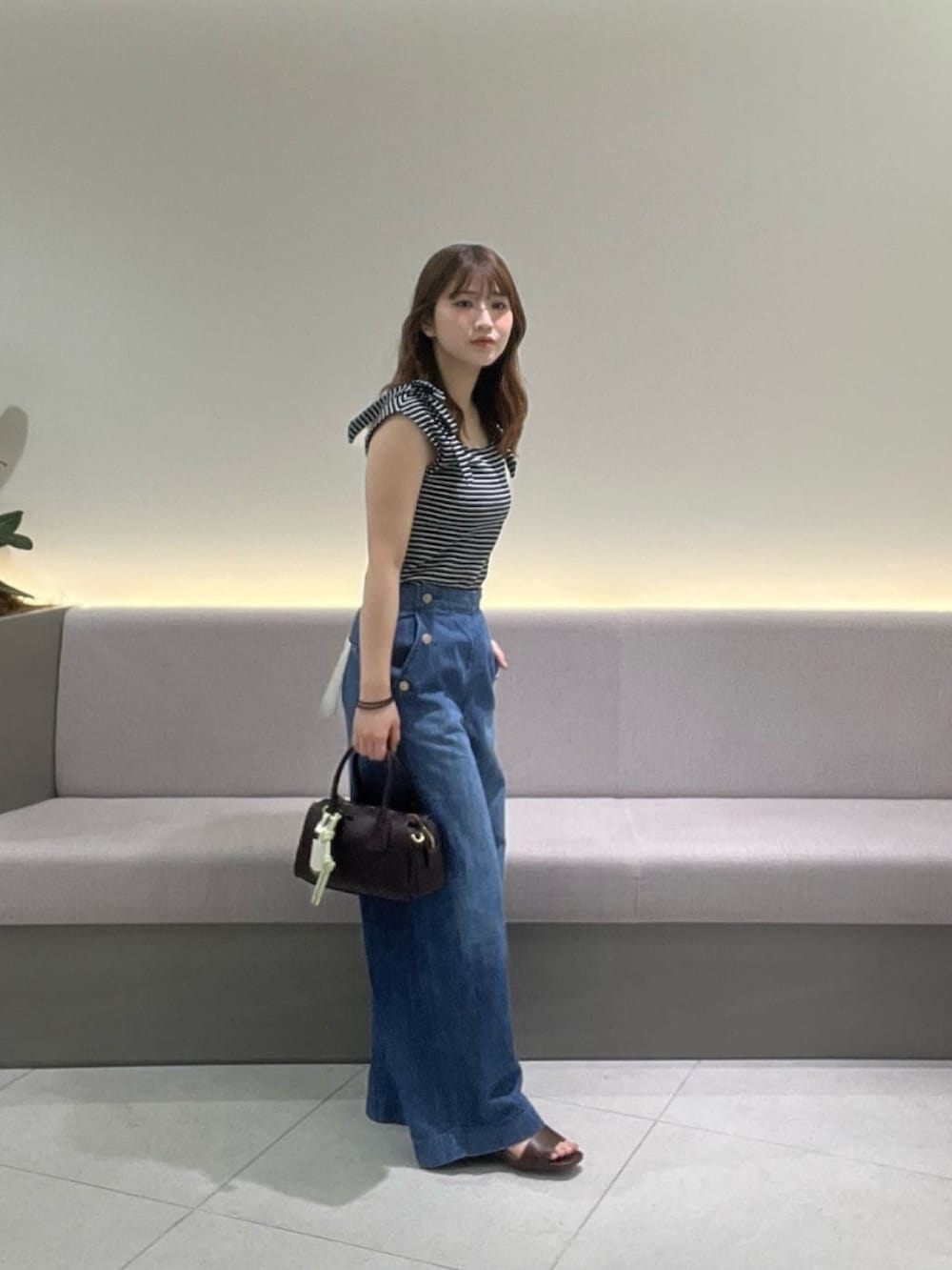 ブルー系のTシャツ/カットソー、ブルー系のデニムパンツ、ブラウン系のサンダルを着用したレディースの夏コーディネートの4枚目の写真