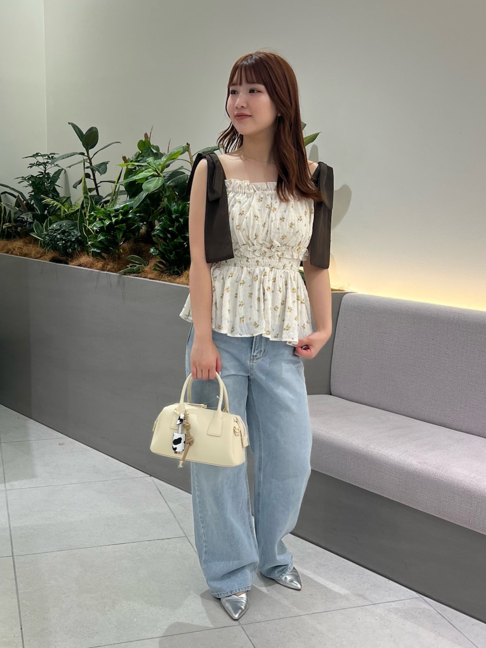 ベージュ系のシャツ/ブラウス、ブルー系のデニムパンツ、ブラウン系のボストンバッグを着用したレディースの夏コーディネートの2枚目の写真