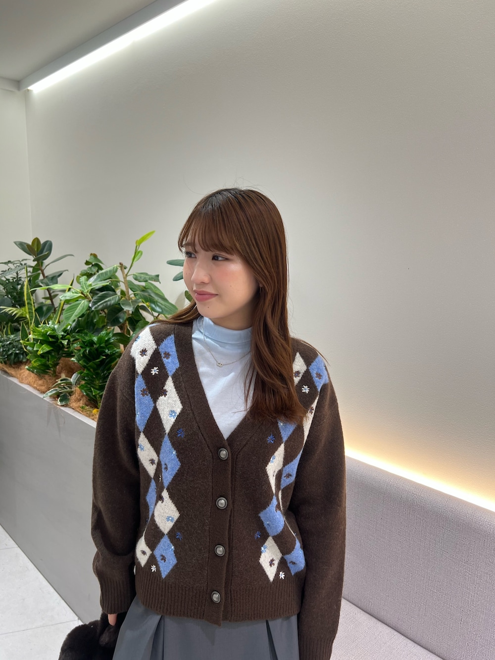 ブラウン系のカーディガン/ボレロ、ブルー系のTシャツ/カットソー、グレー系のスカートを着用したレディースの秋コーディネートの8枚目の写真