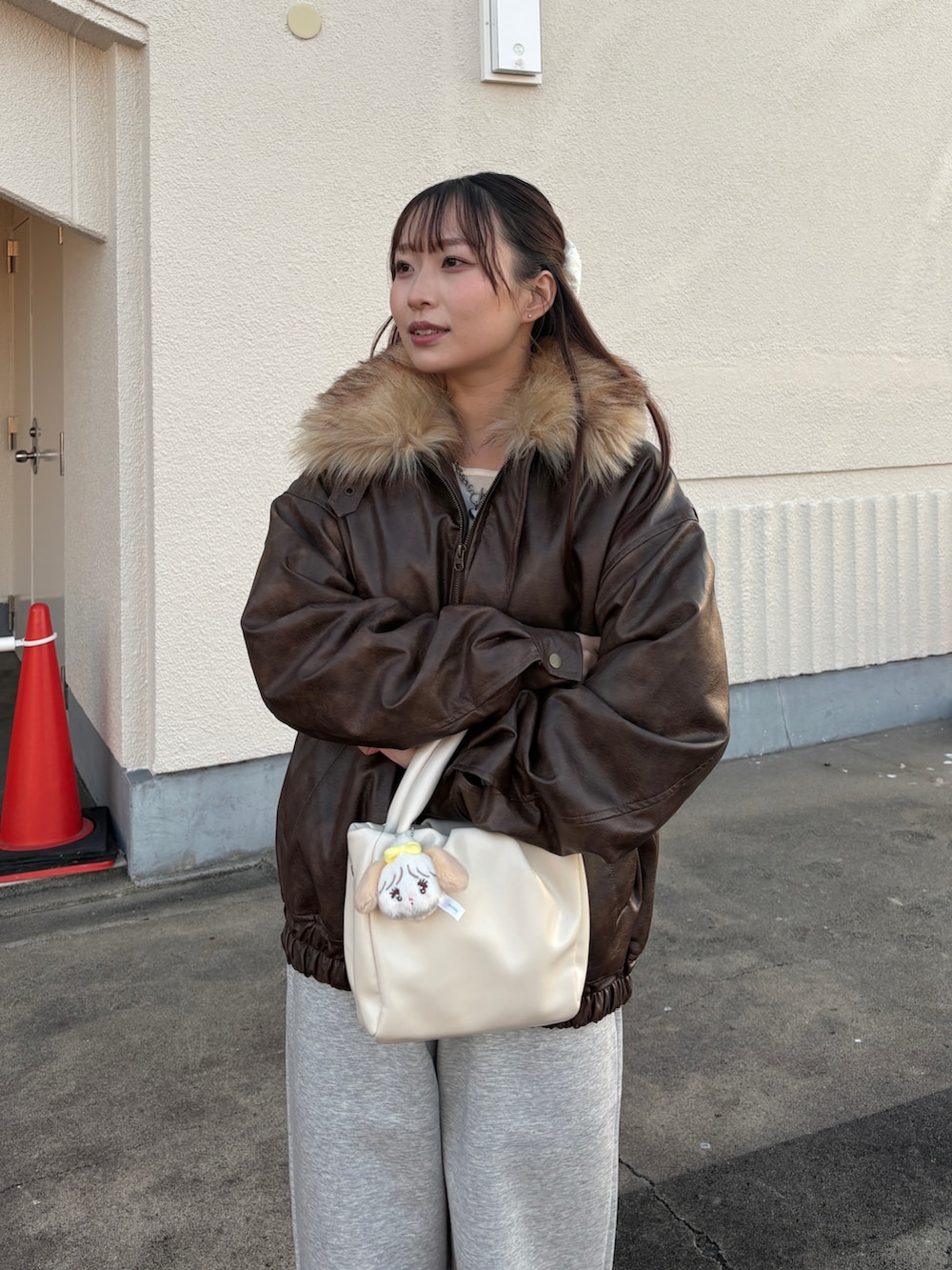 ブラウン系のブルゾン、グレー系のスウェットパンツ、ブラウン系のブーツを着用したレディースの冬コーディネートの2枚目の写真