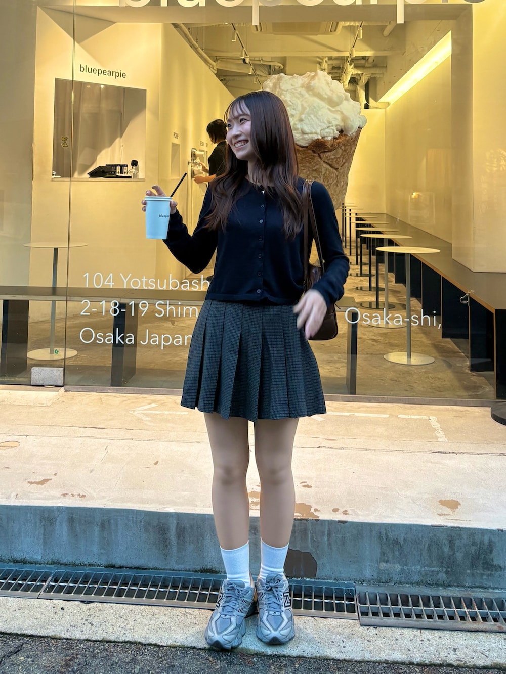 ブラック系のカーディガン/ボレロ、グレー系のスニーカー、グレー系のスカートを着用したレディースの冬コーディネートの2枚目の写真