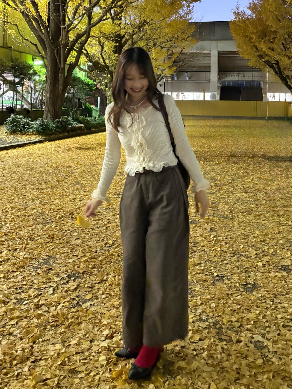 ベージュ系のトップス、ブラウン系のデニムパンツ、ブラック系のパンプスを着用したレディースの冬コーディネートの2枚目の写真