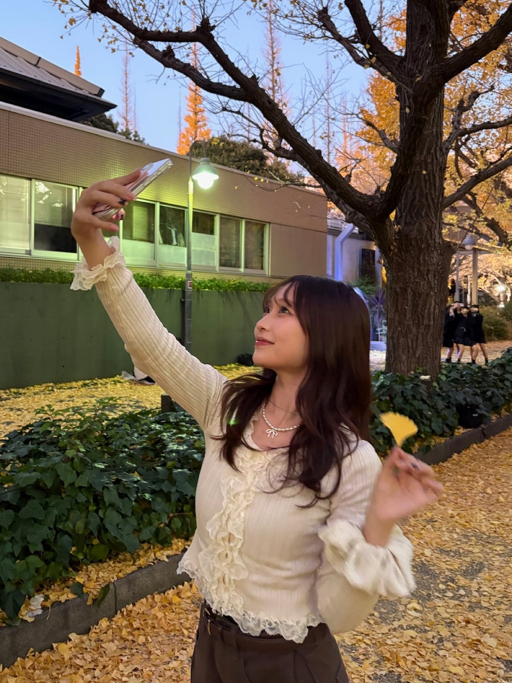 ベージュ系のトップス、ブラウン系のデニムパンツ、ブラック系のパンプスを着用したレディースの冬コーディネートの3枚目の写真