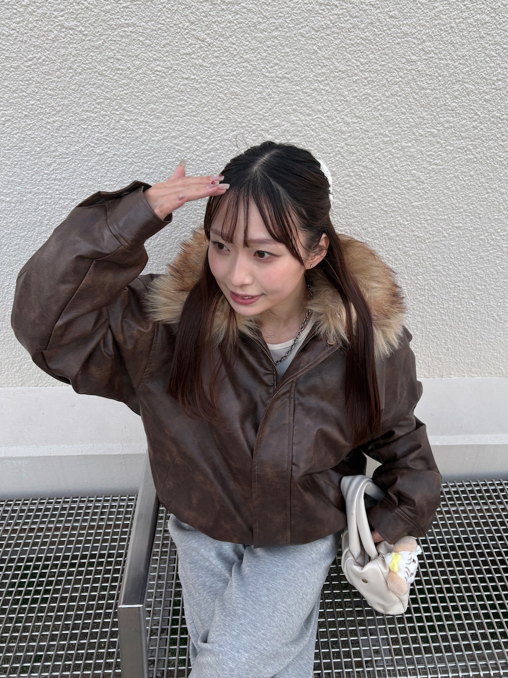 ブラウン系のブルゾン、グレー系のスウェットパンツ、ブラウン系のブーツを着用したレディースの冬コーディネートの3枚目の写真