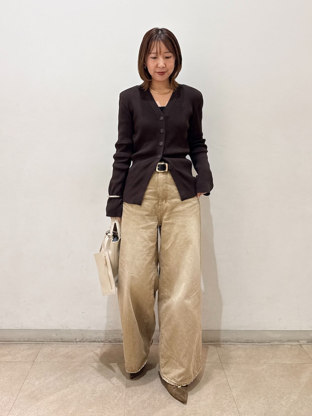 ホワイト系のトートバッグ、イエロー系のパンプスを着用したレディースの春コーディネートの3枚目の写真