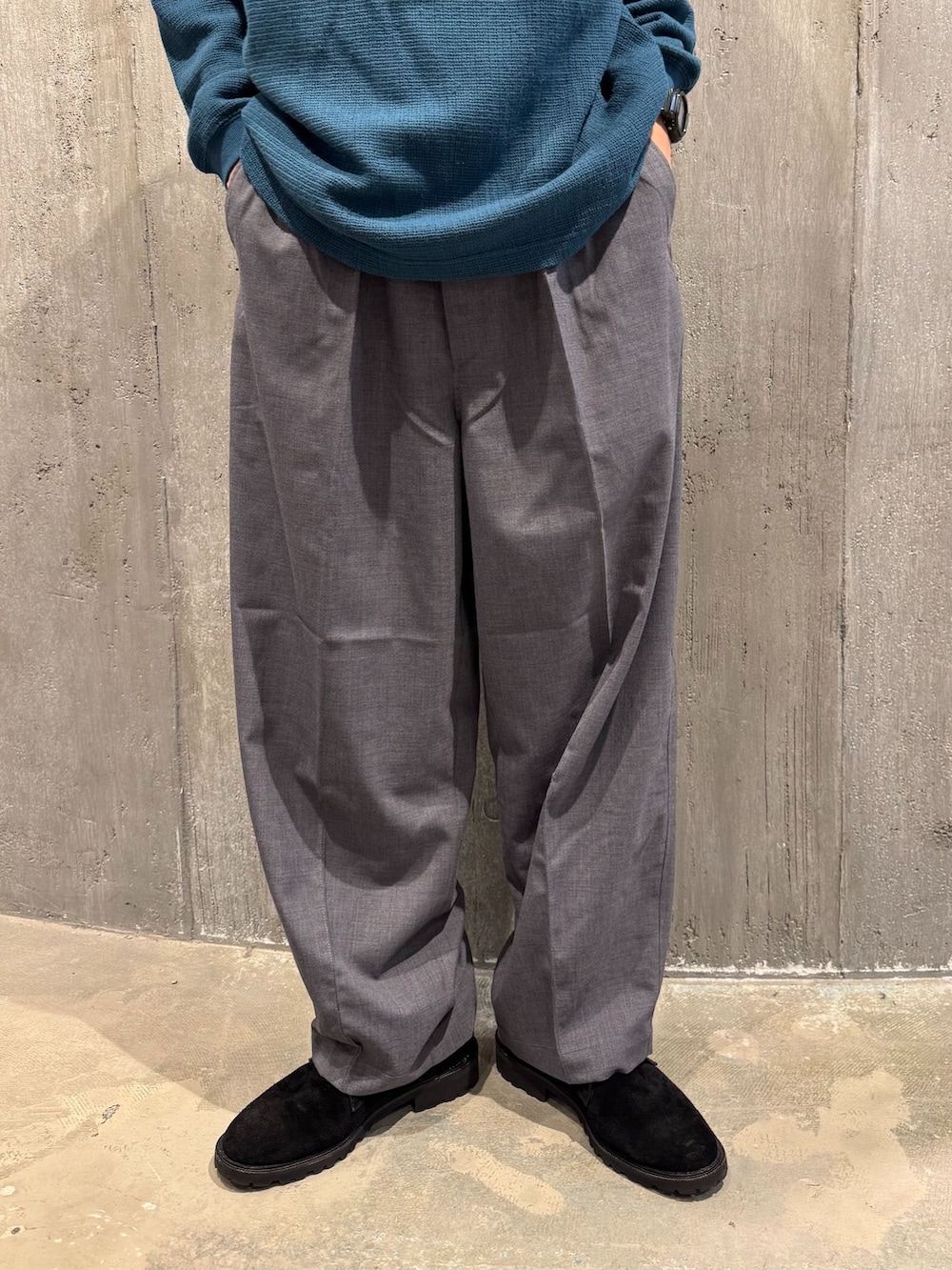 グレー系のスラックス、グリーン系のTシャツ/カットソー、ブラック系のその他シューズを着用したメンズの秋コーディネートの3枚目の写真