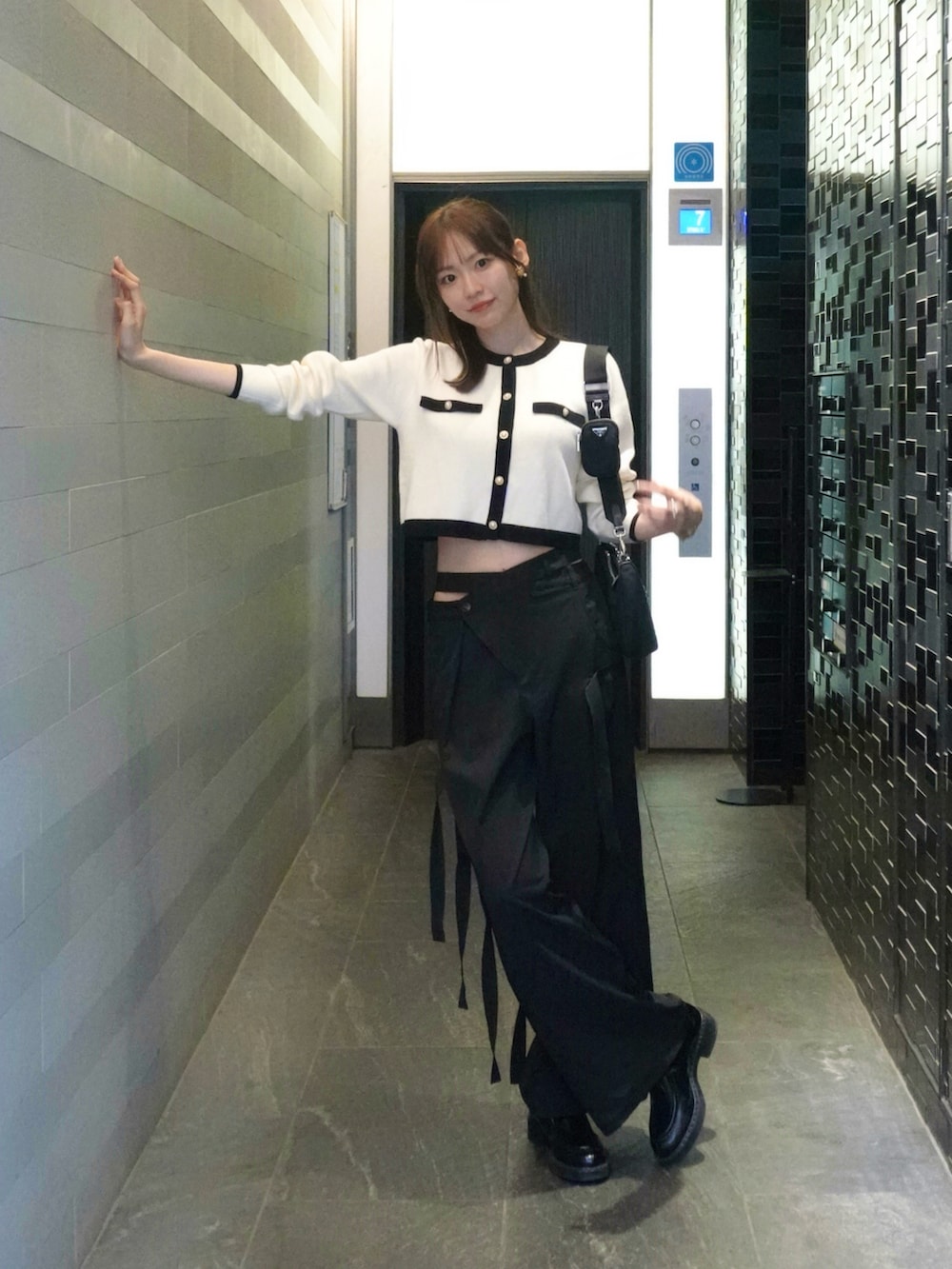 ホワイト系のカーディガン/ボレロ、ブラック系のスラックスを着用したレディースの秋コーディネートの2枚目の写真