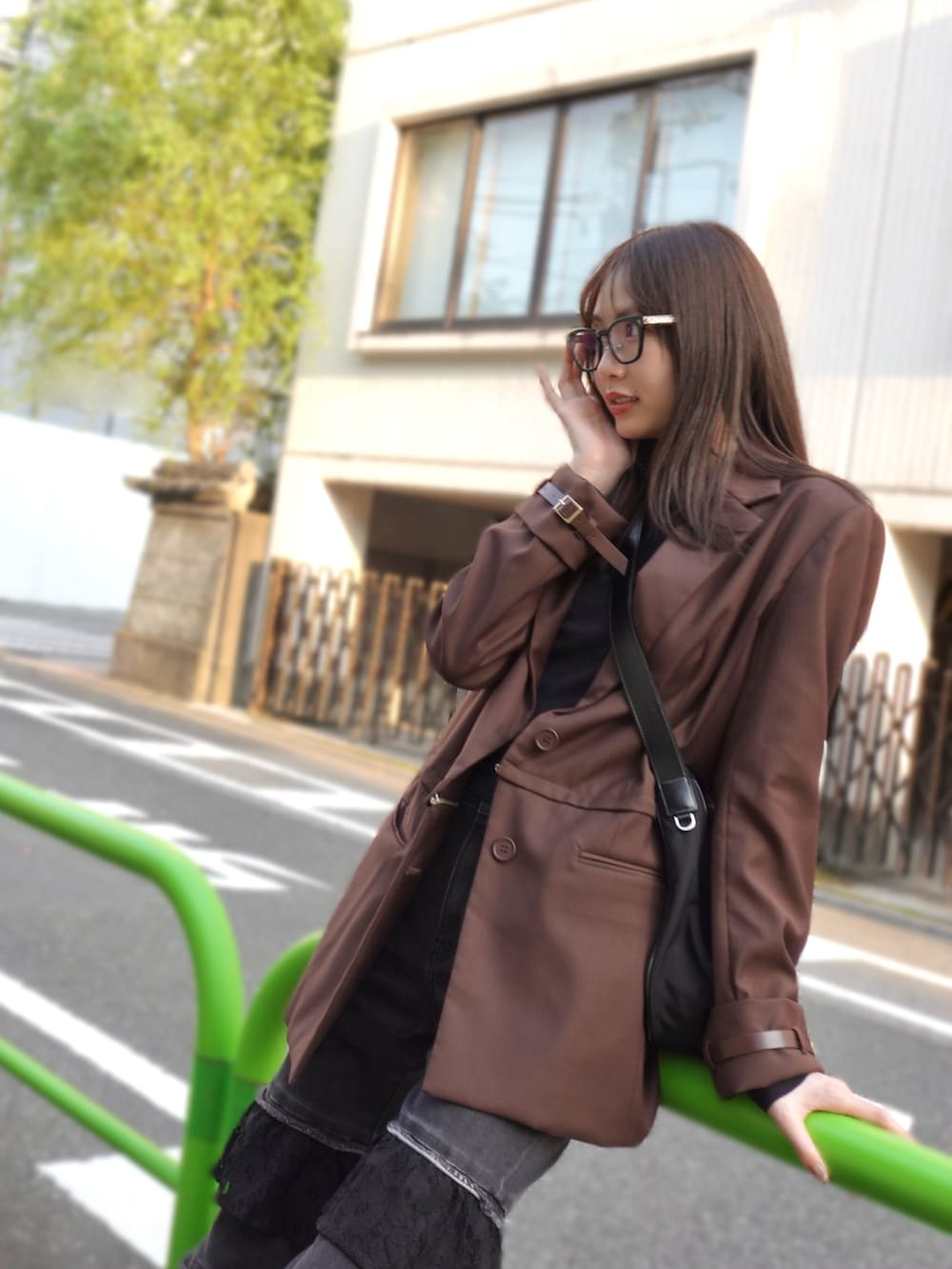 ブラック系のスニーカー、ブラウン系のテーラードジャケット、ブラック系のデニムパンツを着用したレディースの冬コーディネートの3枚目の写真