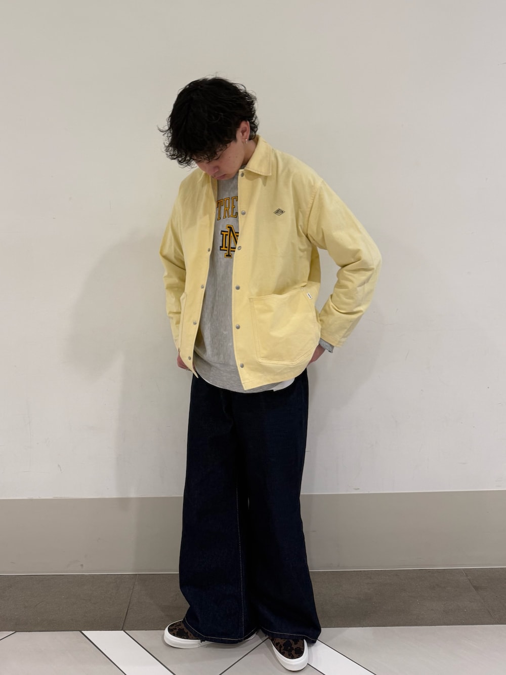 ブラウン系のスニーカー、ブルー系のデニムパンツを着用したメンズの春コーディネートの2枚目の写真