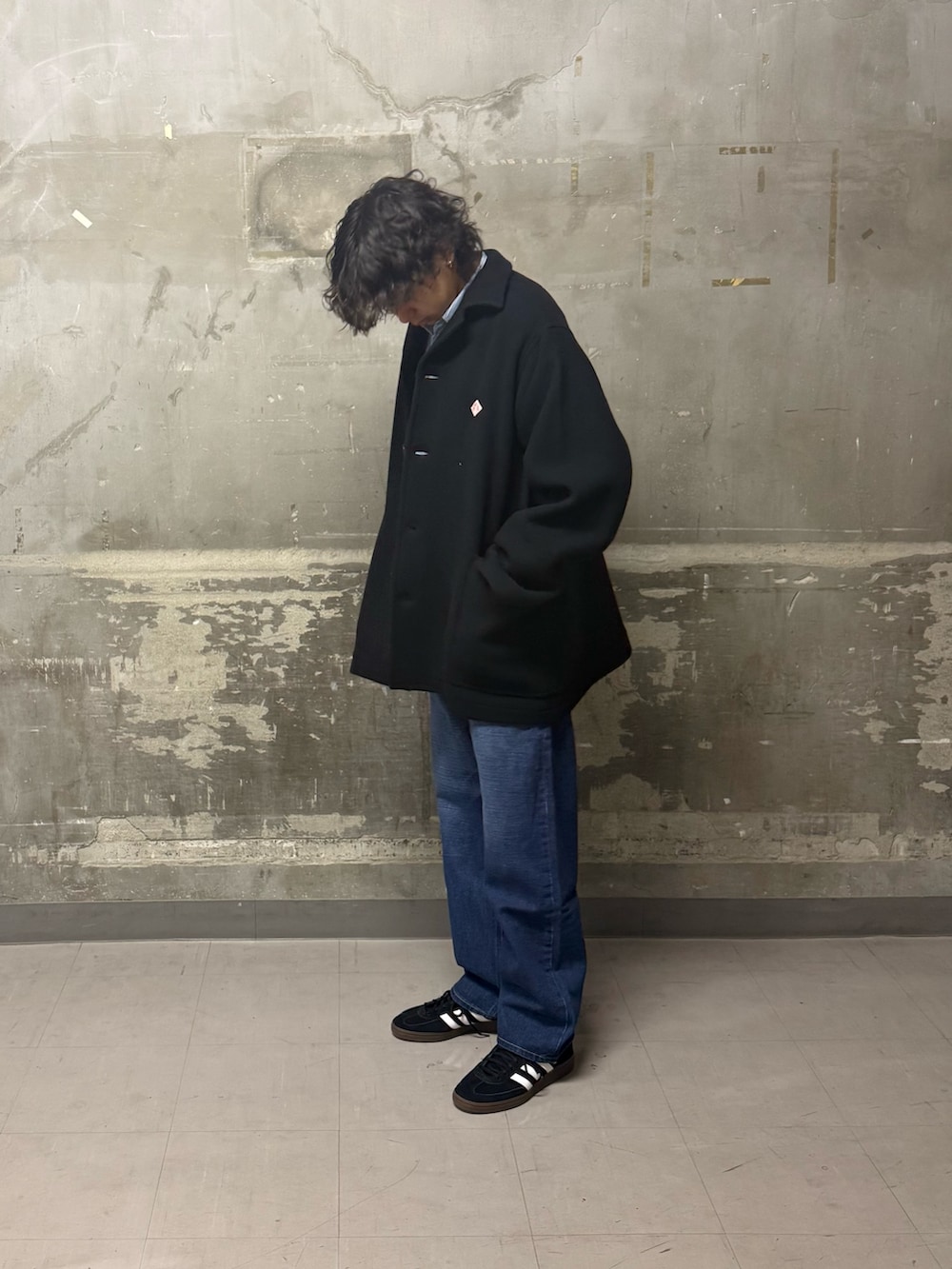 ブルー系のデニムパンツ、ブラック系のスニーカー、ブルー系のテーラードジャケットを着用したメンズの冬コーディネートの4枚目の写真