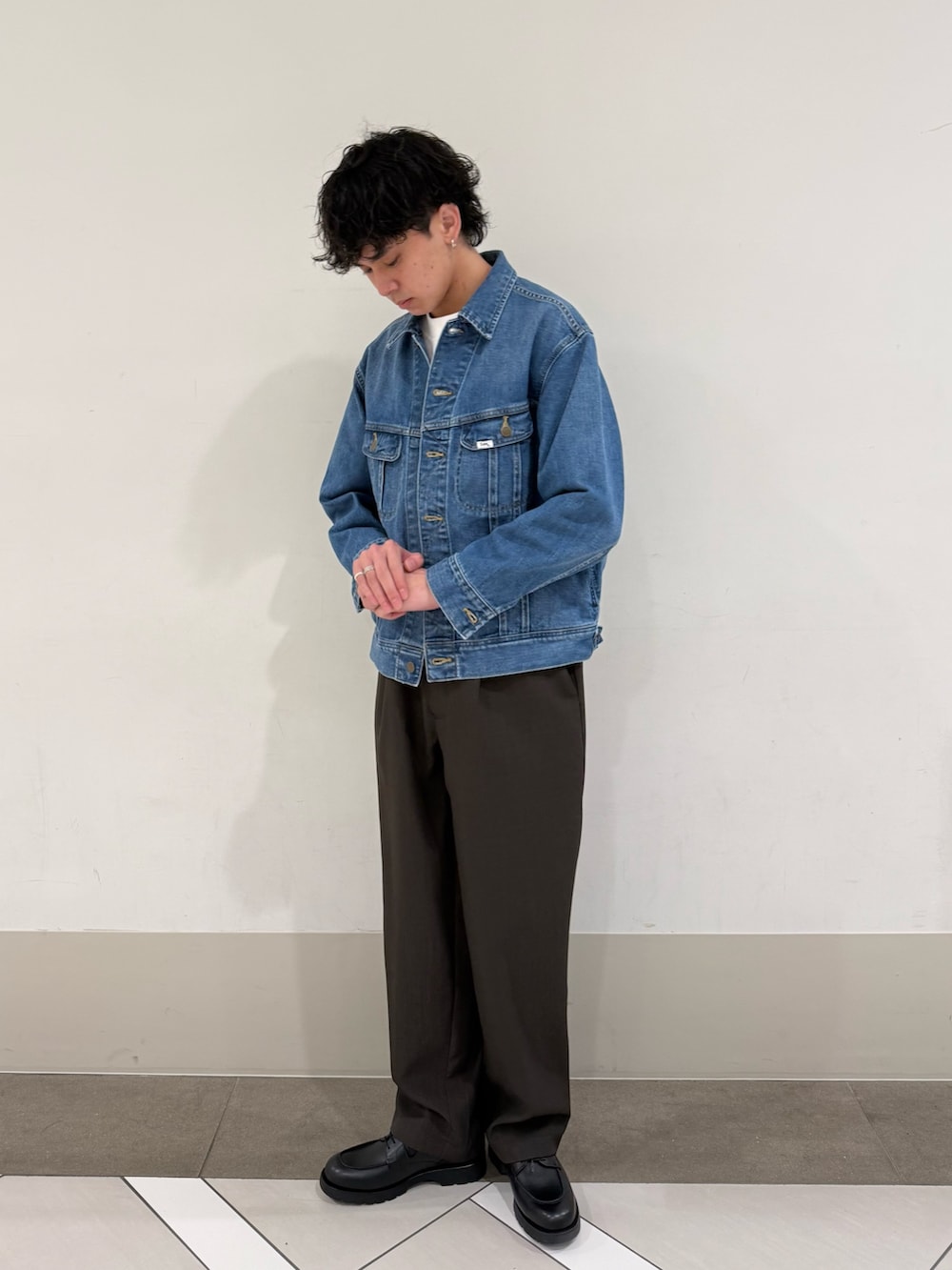 ブラウン系のその他パンツ、ブルー系のデニムジャケット、ブラック系のドレスシューズを着用したメンズの春コーディネートの3枚目の写真