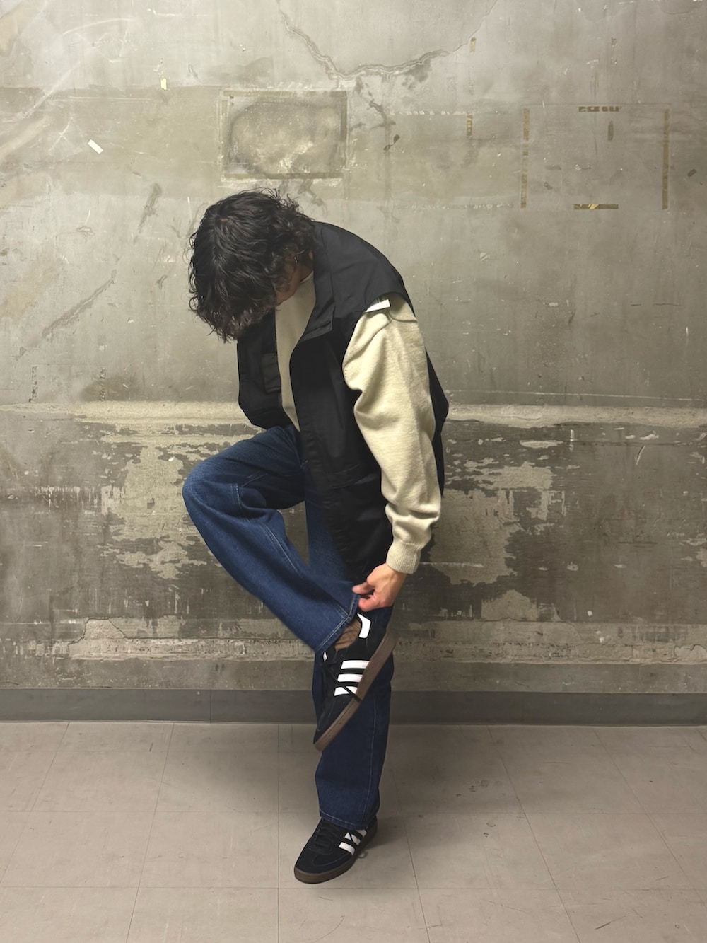 ブルー系のデニムパンツ、ブラック系のスニーカー、ブラック系のその他アウターを着用したメンズの冬コーディネートの2枚目の写真