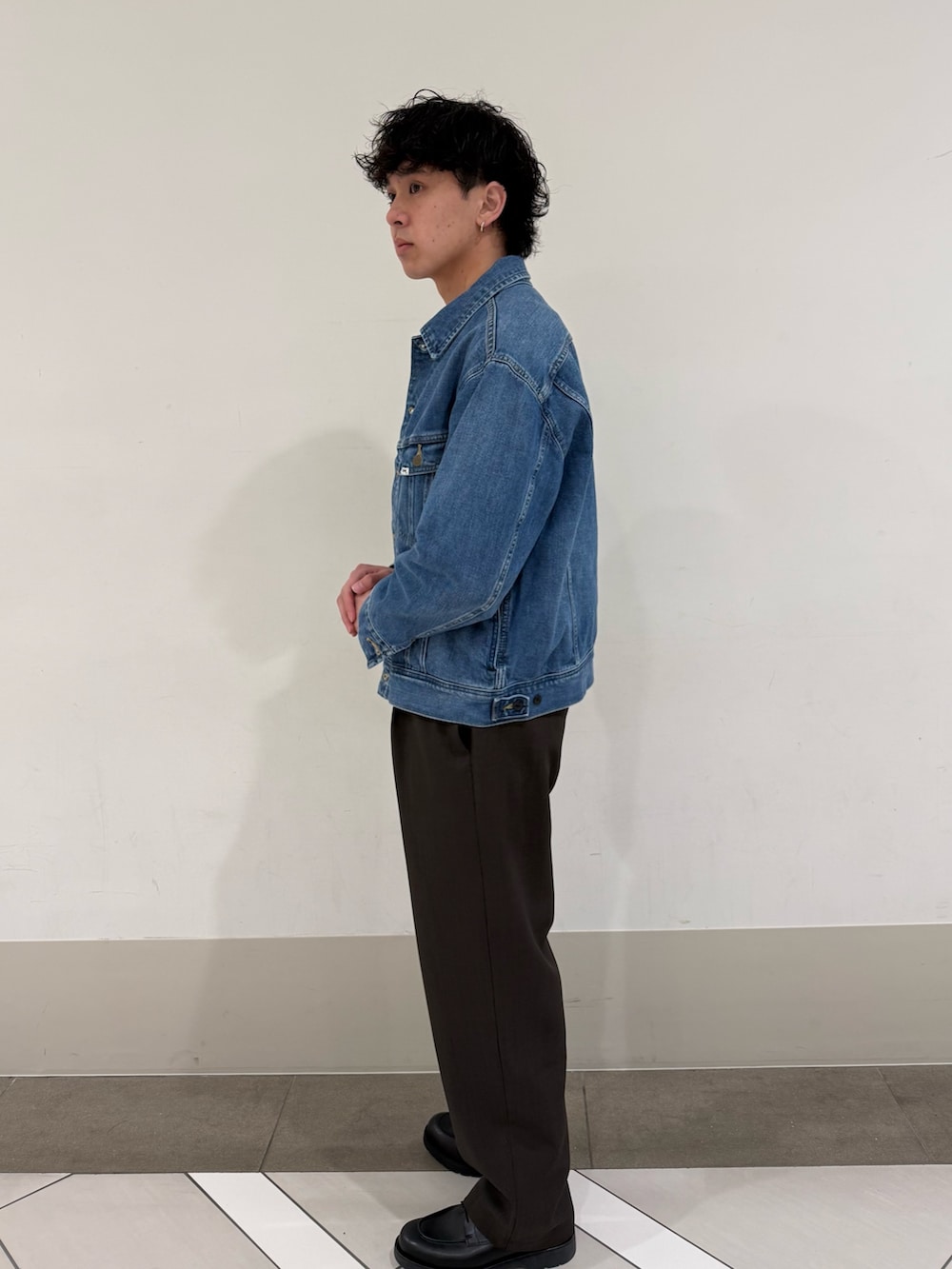 ブラウン系のその他パンツ、ブルー系のデニムジャケット、ブラック系のドレスシューズを着用したメンズの春コーディネートの2枚目の写真