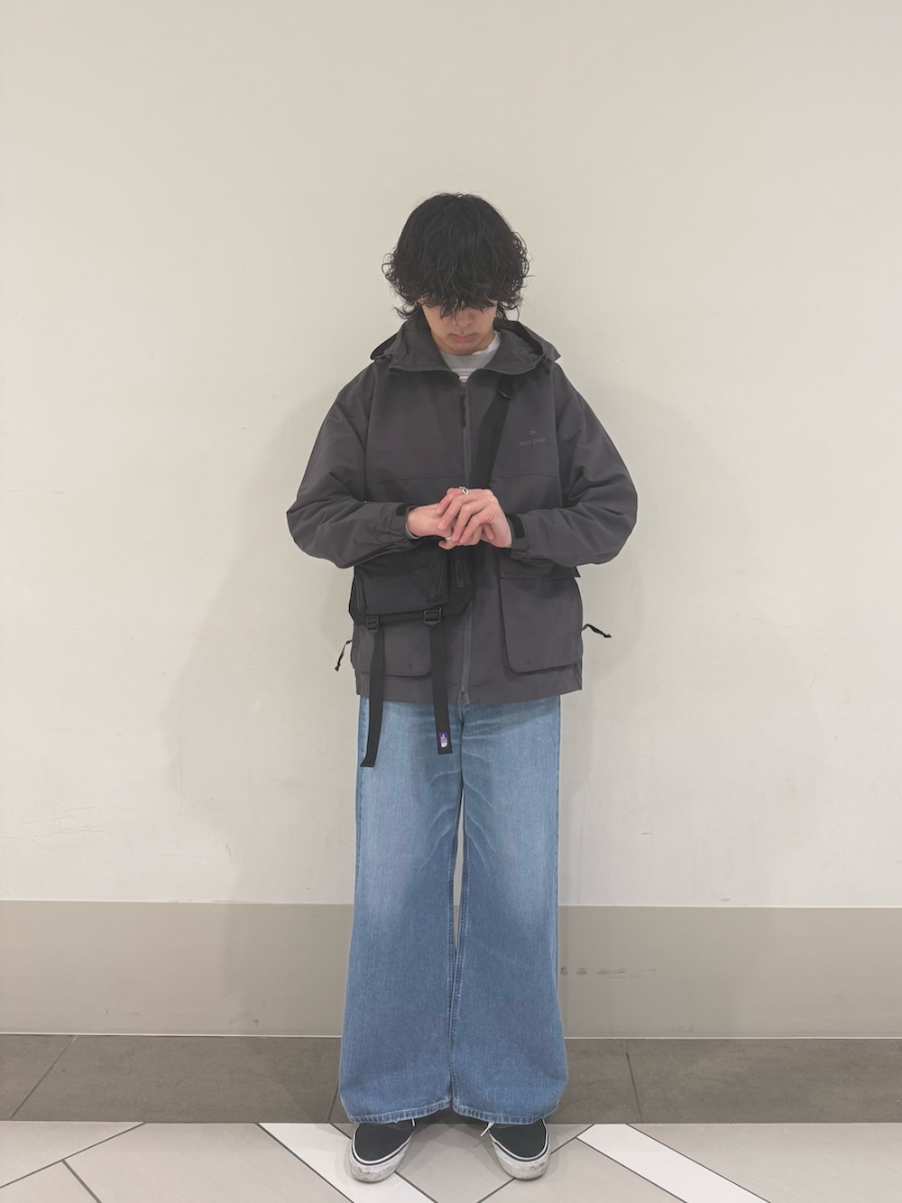 グレー系のマウンテンパーカー、ブルー系のデニムパンツを着用したメンズの冬コーディネートの3枚目の写真