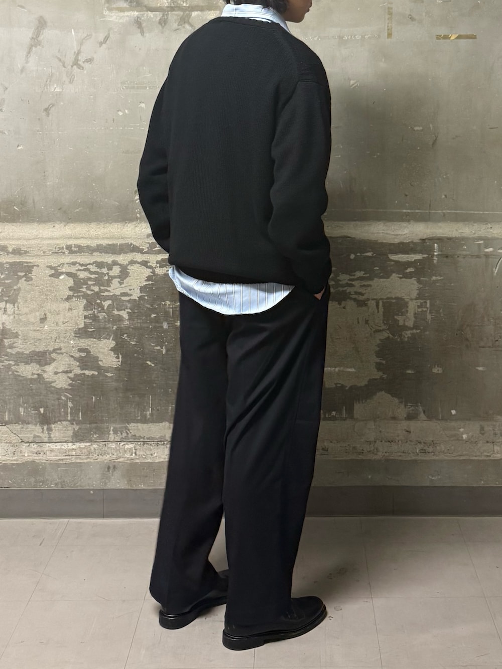 ブラック系のニット/セーター、ブルー系のその他パンツ、ブルー系のシャツ/ブラウスを着用したメンズの冬コーディネートの4枚目の写真