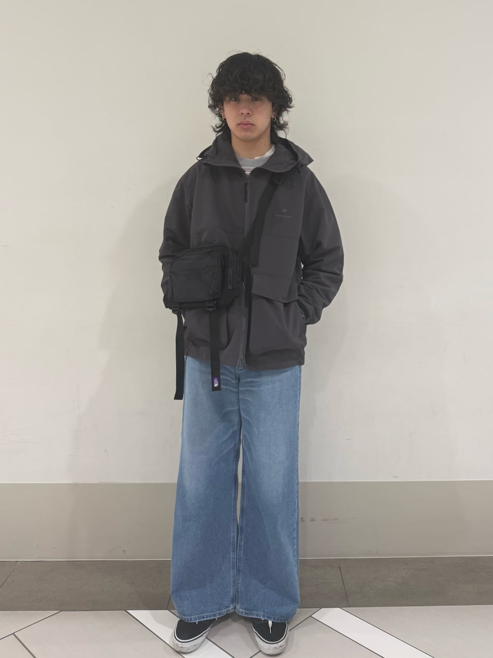 グレー系のマウンテンパーカー、ブルー系のデニムパンツを着用したメンズの冬コーディネートの4枚目の写真