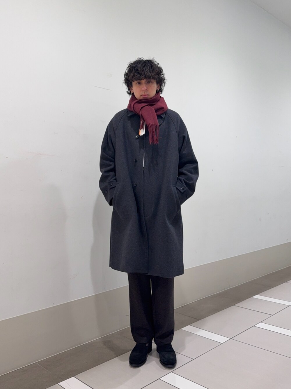 グレー系のステンカラーコート、ブラウン系のその他パンツ、ブラック系のドレスシューズを着用したメンズの冬コーディネートの2枚目の写真