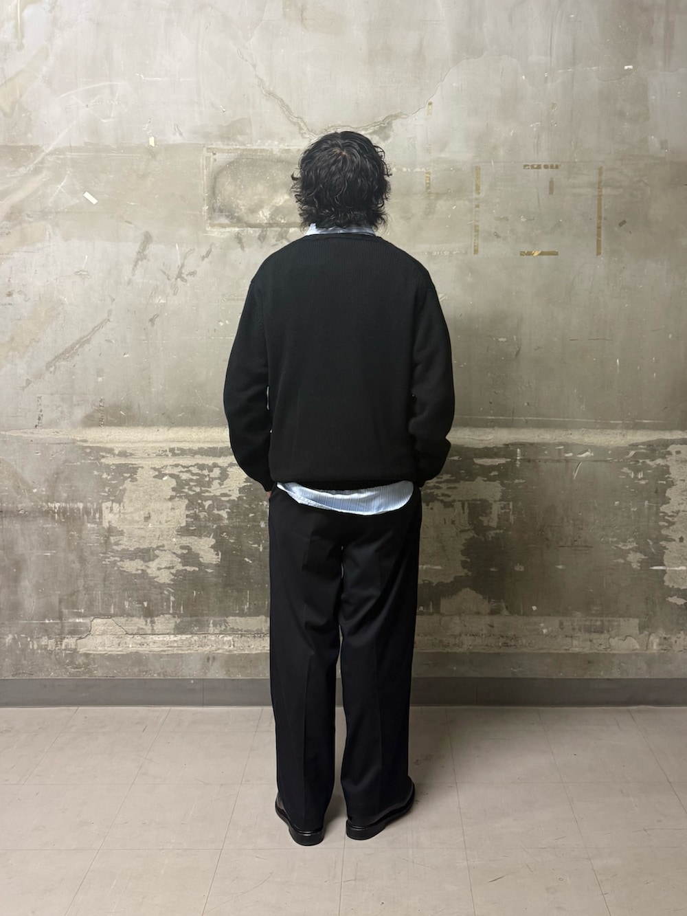 ブラック系のニット/セーター、ブルー系のその他パンツ、ブルー系のシャツ/ブラウスを着用したメンズの冬コーディネートの2枚目の写真