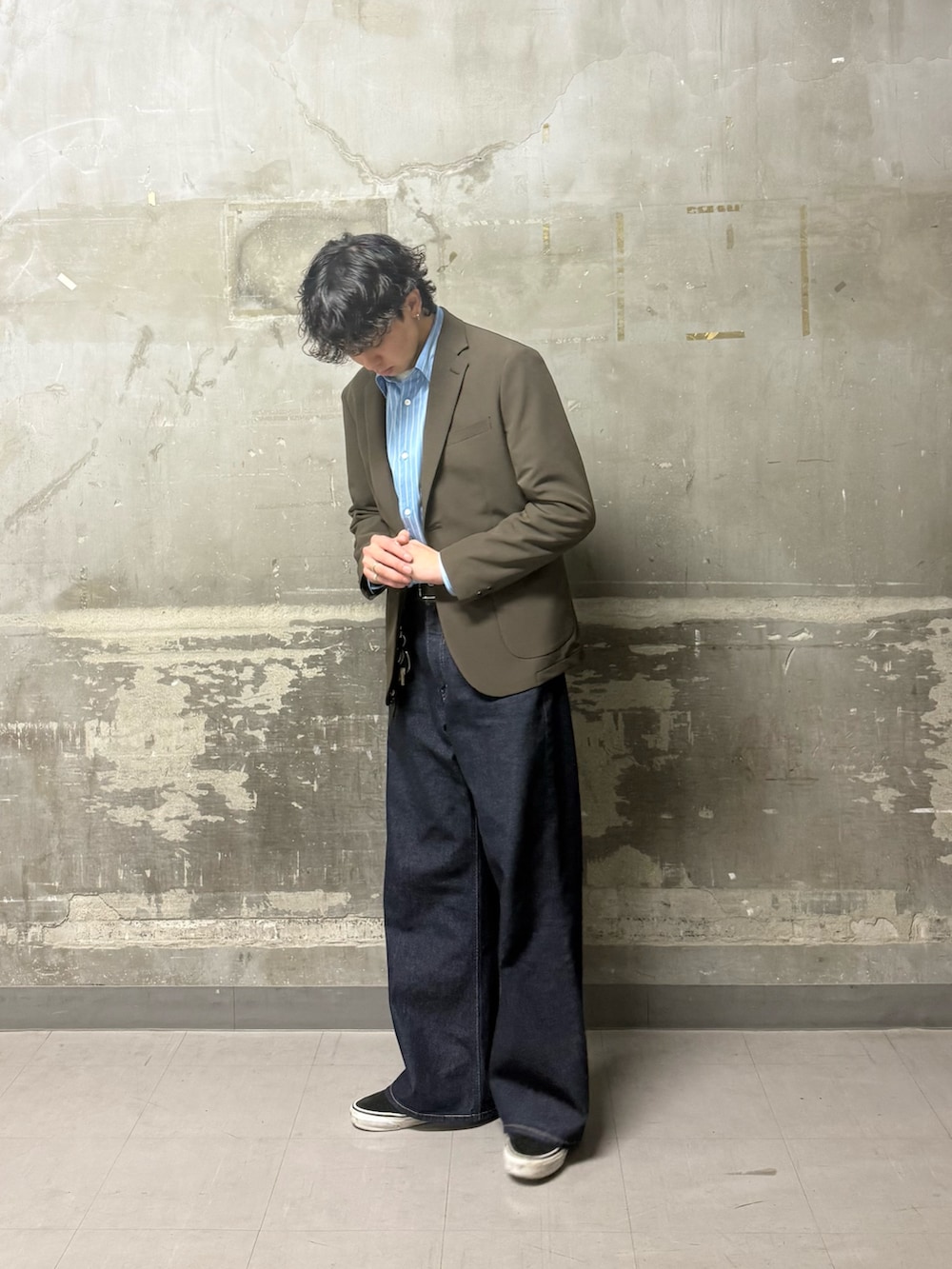 ブラウン系のその他アウター、ブルー系のデニムパンツ、ブラック系のベルトを着用したメンズの春コーディネートの4枚目の写真