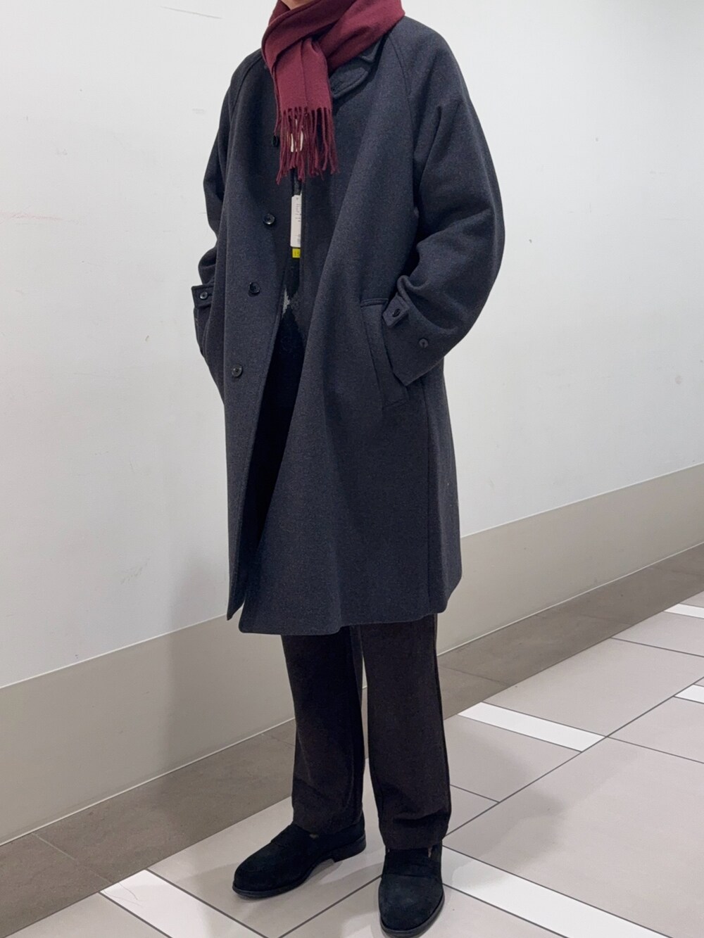 グレー系のステンカラーコート、ブラウン系のその他パンツ、ブラック系のドレスシューズを着用したメンズの冬コーディネートの4枚目の写真