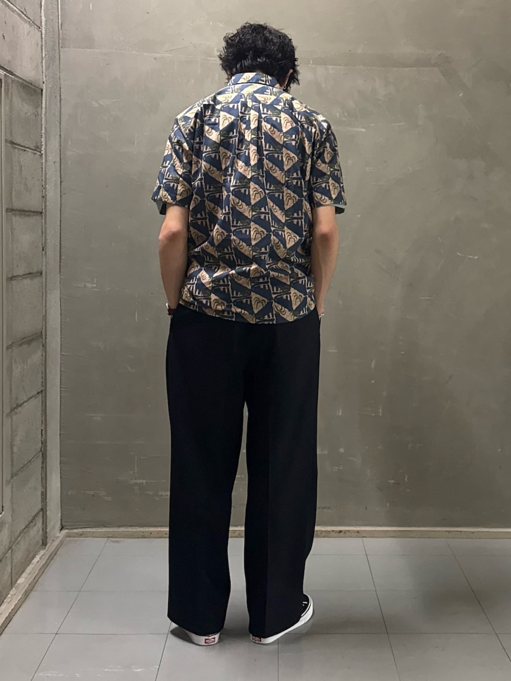 グリーン系のTシャツ/カットソー、ブラック系のスニーカーを着用したメンズの春コーディネートの3枚目の写真