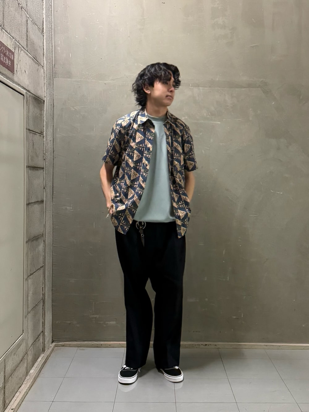 グリーン系のTシャツ/カットソー、ブラック系のスニーカーを着用したメンズの春コーディネートの4枚目の写真