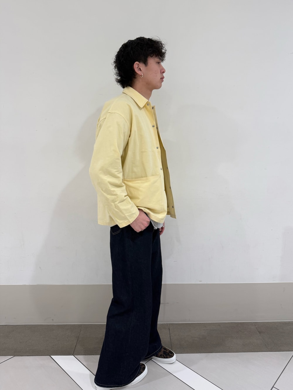 ブラウン系のスニーカー、ブルー系のデニムパンツを着用したメンズの春コーディネートの3枚目の写真