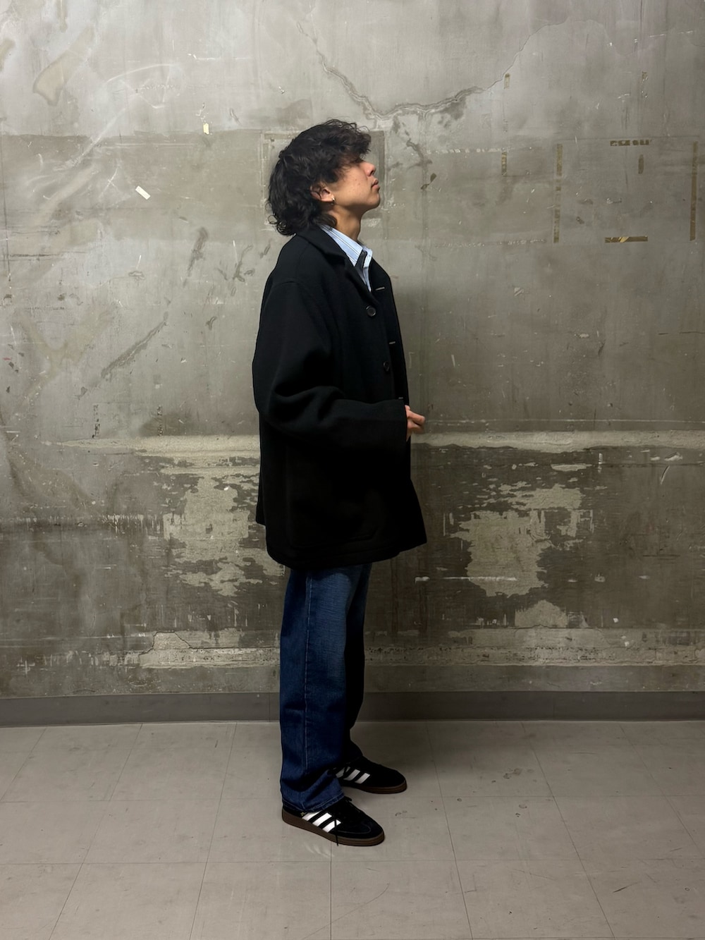 ブルー系のデニムパンツ、ブラック系のスニーカー、ブルー系のテーラードジャケットを着用したメンズの冬コーディネートの3枚目の写真