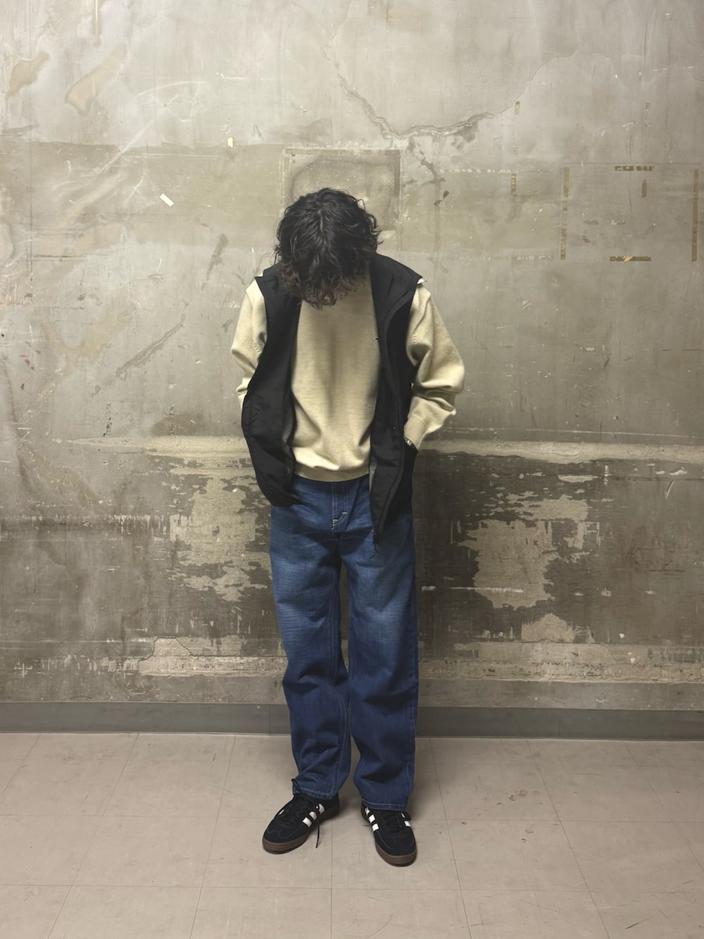 ブルー系のデニムパンツ、ブラック系のスニーカー、ブラック系のその他アウターを着用したメンズの冬コーディネートの4枚目の写真