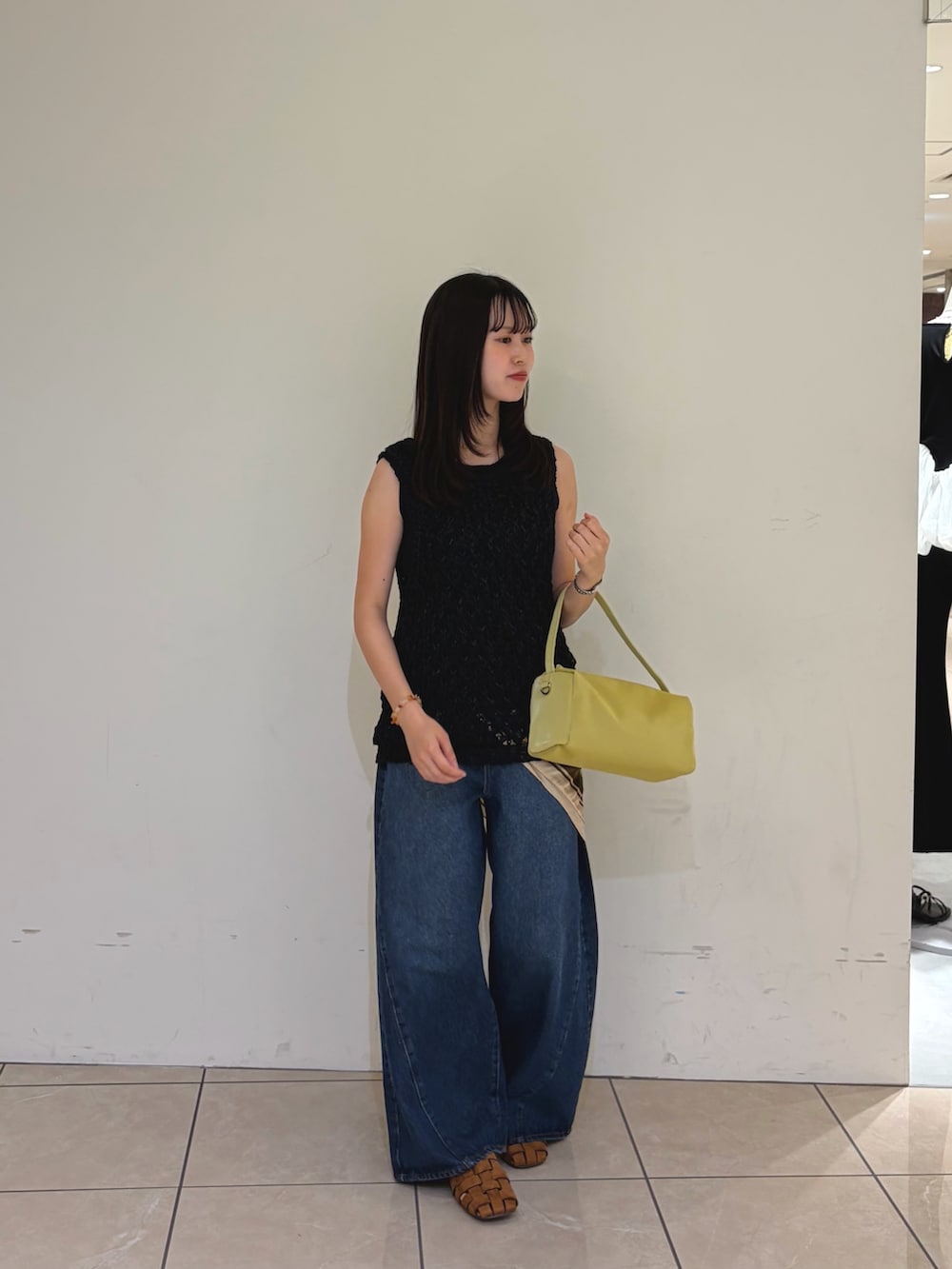 ブラック系のニット/セーター、ブルー系のデニムパンツ、ブラウン系のサンダルを着用したレディースの夏コーディネートの3枚目の写真