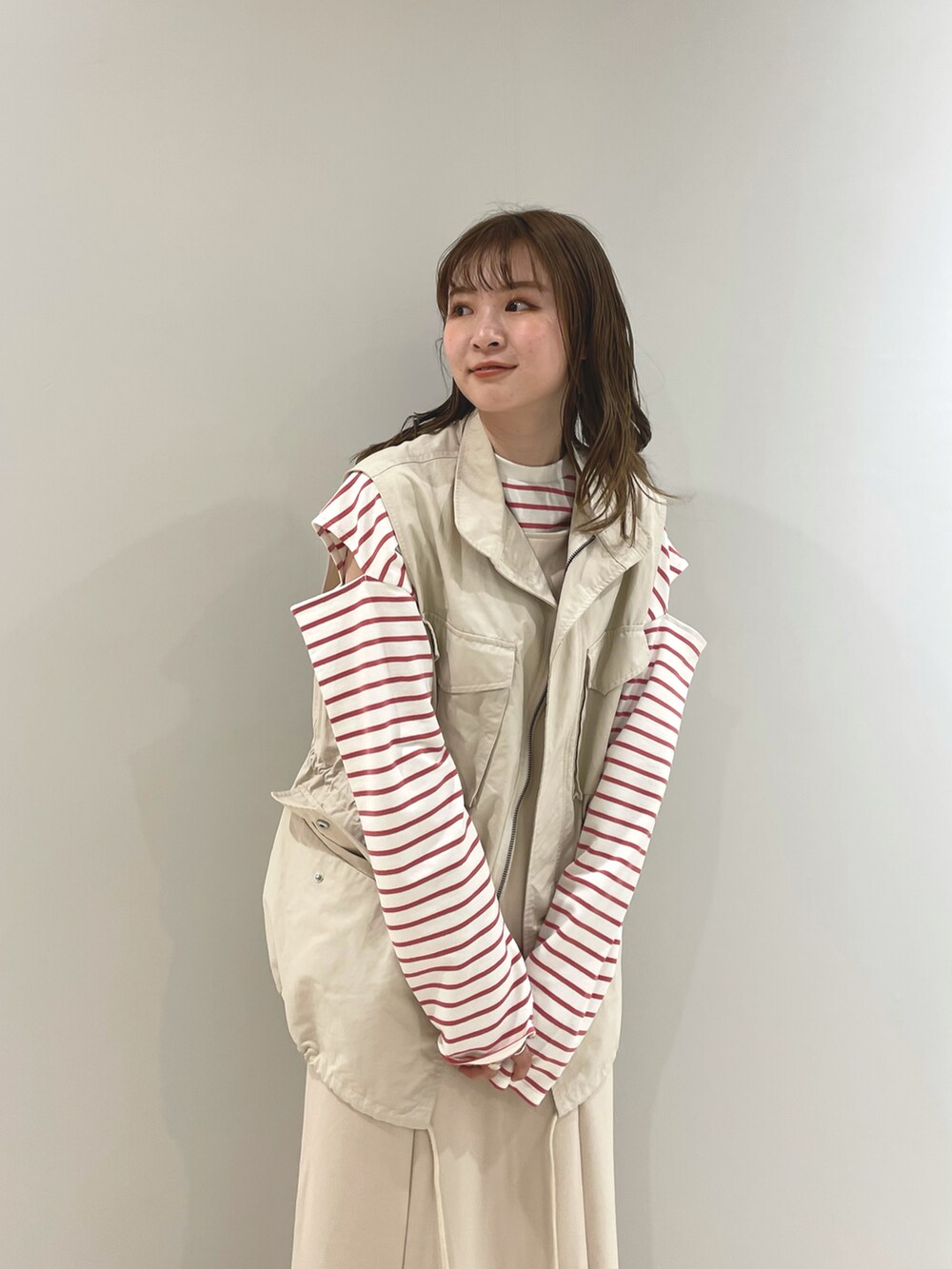 ホワイト系のワンピース、レッド系のTシャツ/カットソー、ホワイト系のベストを着用したレディースの春コーディネートの2枚目の写真