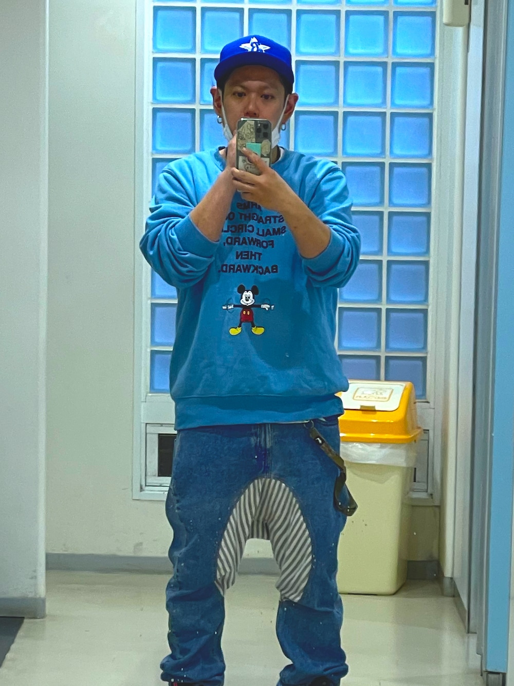 ブルー系のスウェット、ブルー系のデニムパンツ、ブルー系のキャップを着用したメンズの春コーディネートの2枚目の写真