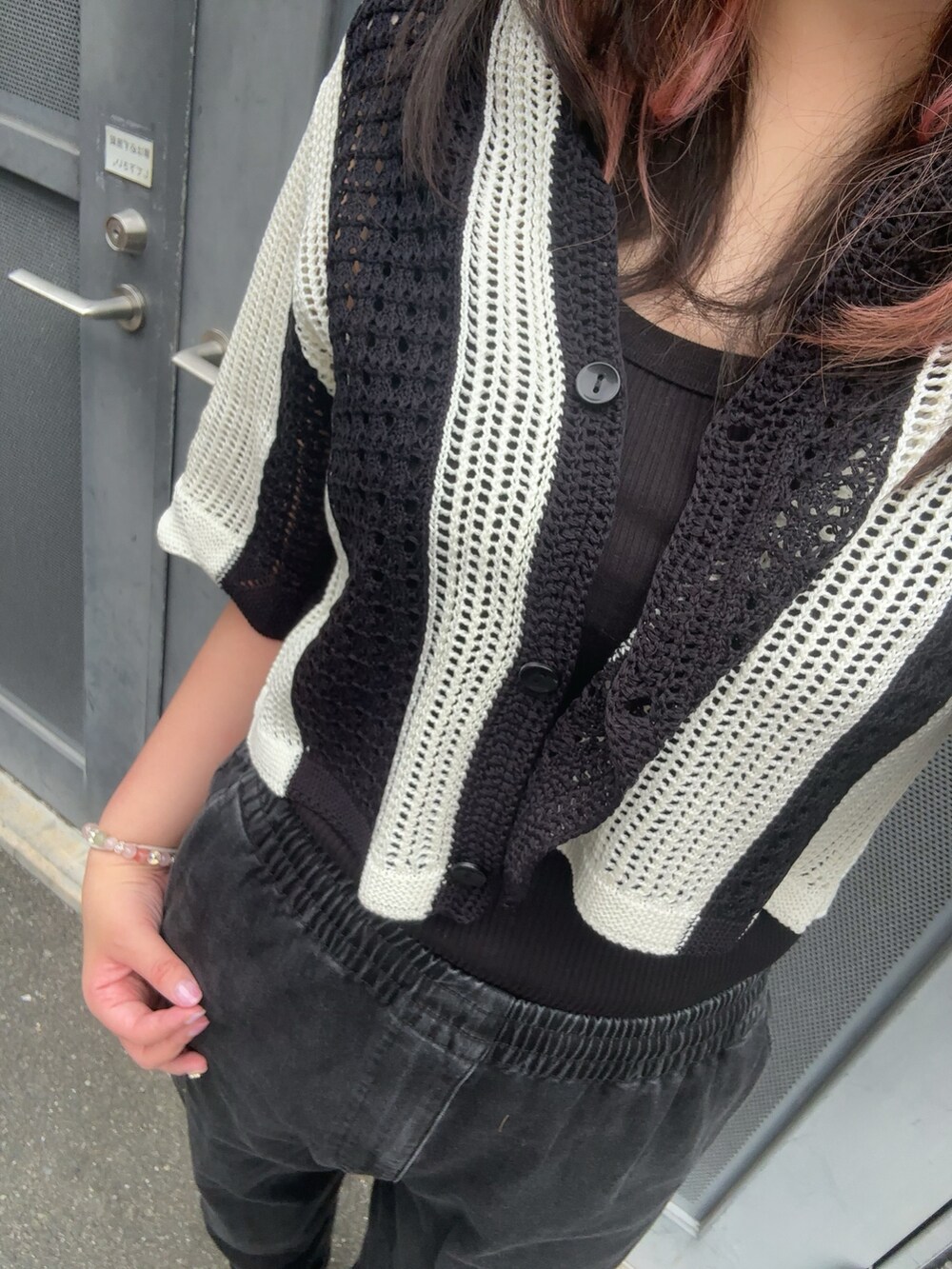 ブラック系のパンツ、ブラック系のタンクトップ、ブラック系のサンダルを着用したレディースの夏コーディネートの2枚目の写真